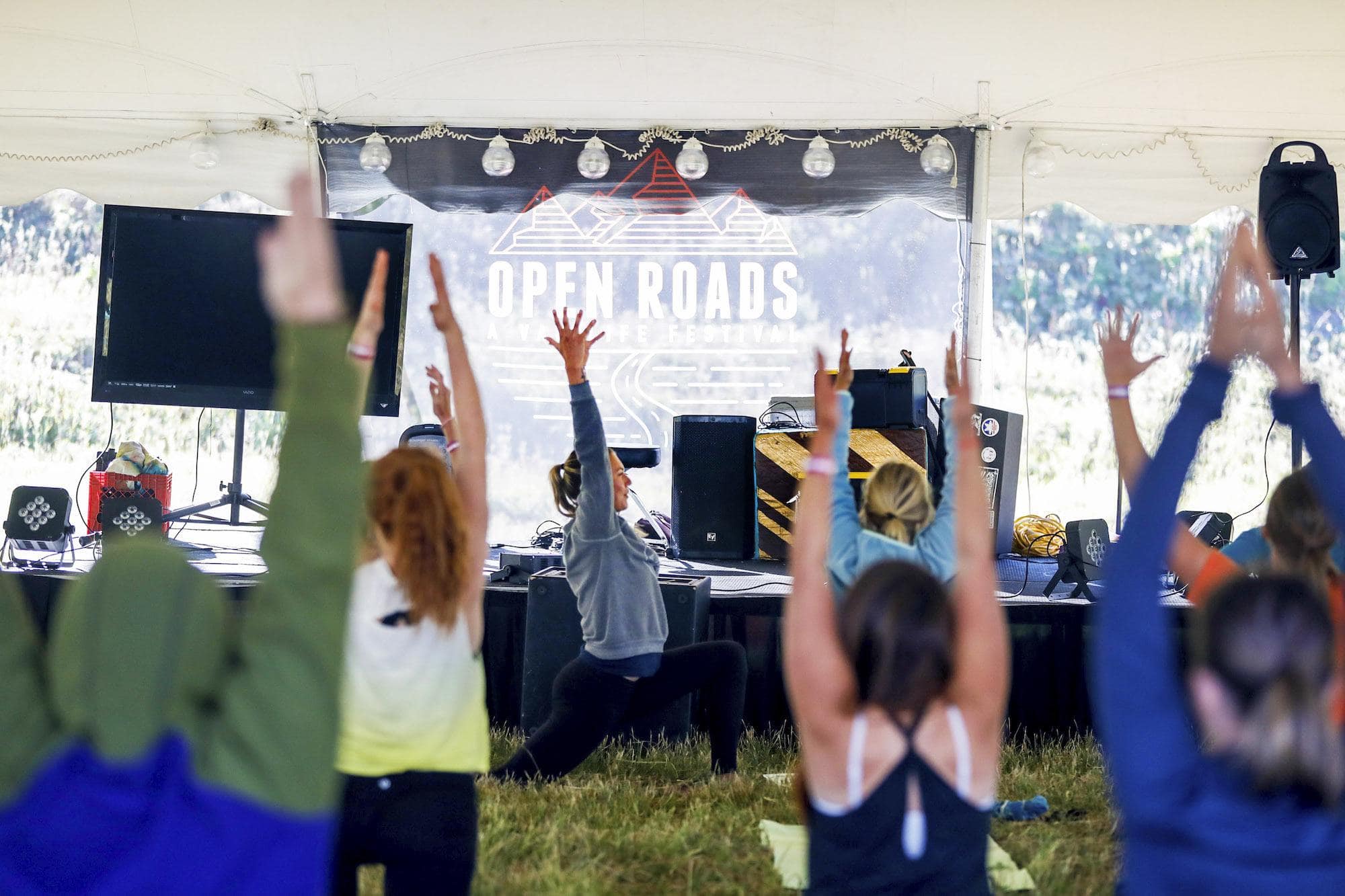 A group of women doing yoga at Open Roads Fest, a van life festival and campout in McCall, Idaho