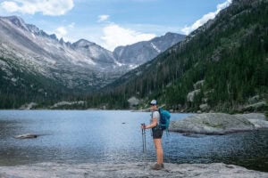 Kristen Bor in hiking gear standing at the edge of a lake in Rocky Mountain National Park