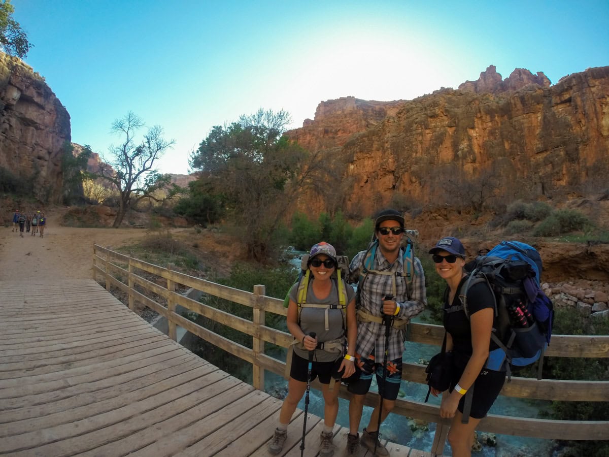 Group of hikers standing on a bridge over Havasu Creek