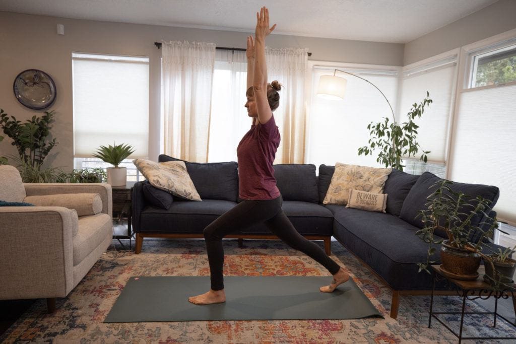 A woman doing yoga at home // Learn how to train for hiking with easy tips and tricks so you can get in shape and be prepared for your next hiking adventure.