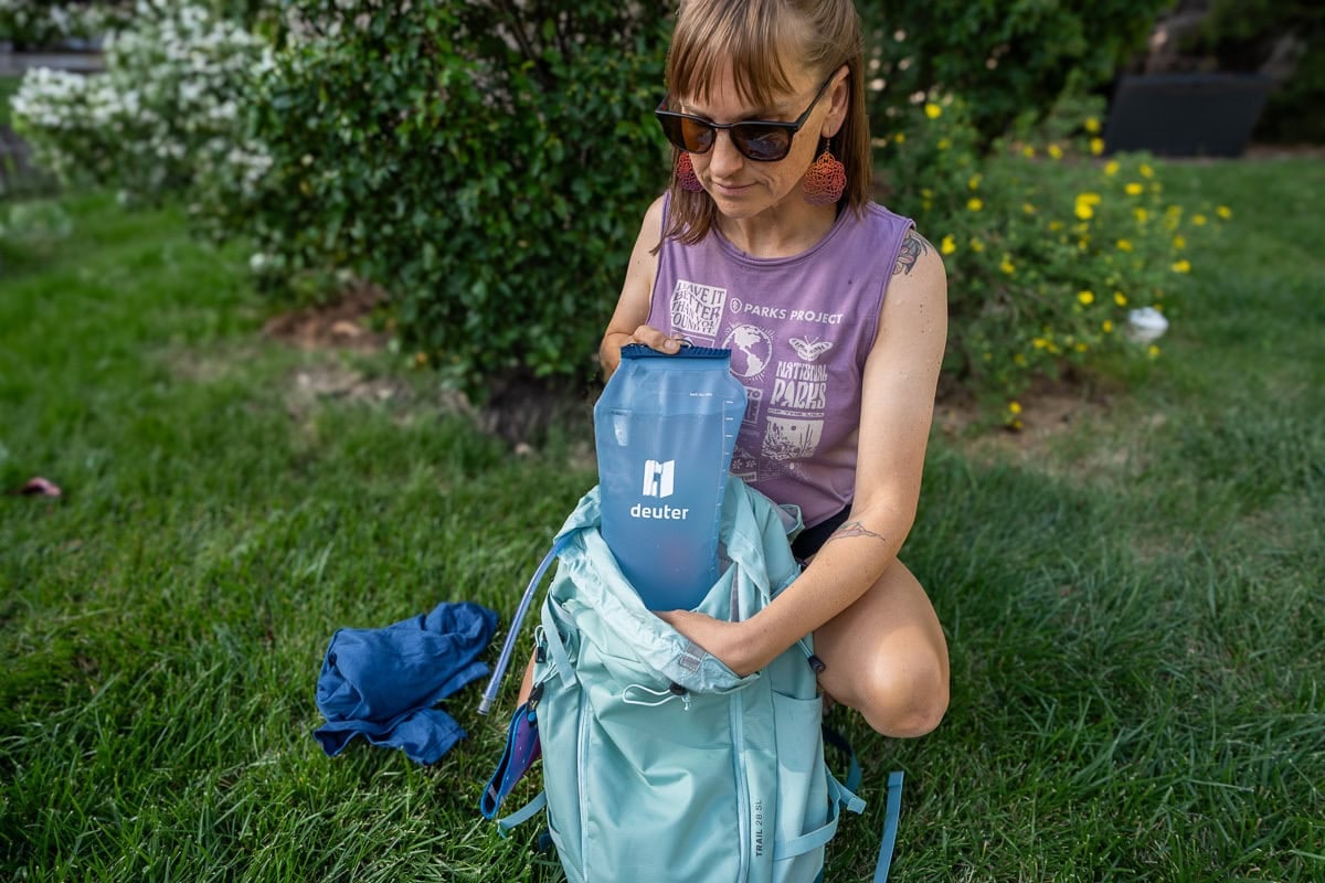 Kristen Bor putting a hydration reservoir into the hydration sleeve on the deuter trail sl backpack
