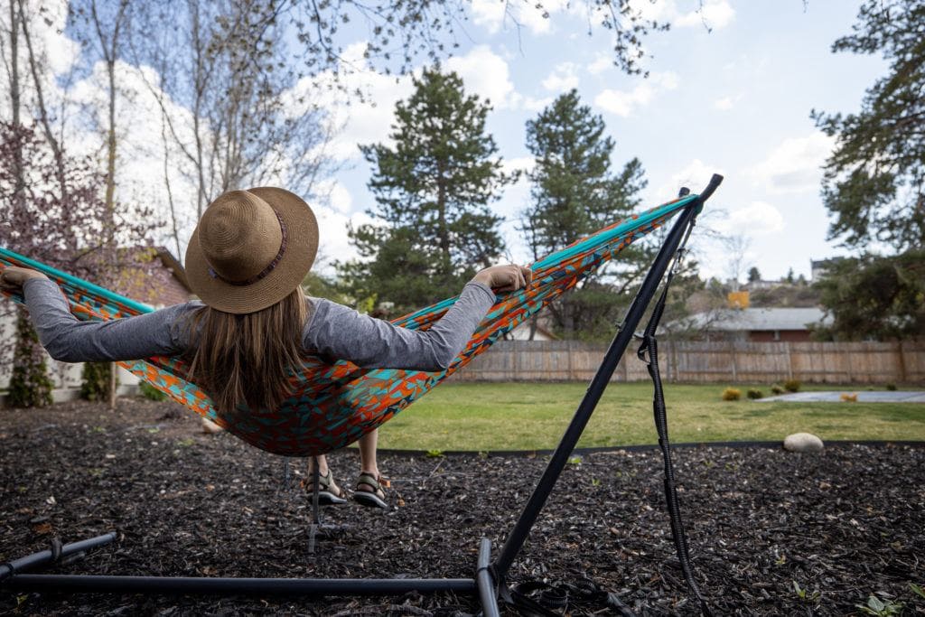 Bearfoot Theory founder Kristen Bor swinging in a colorful ENO hammock in her backyard