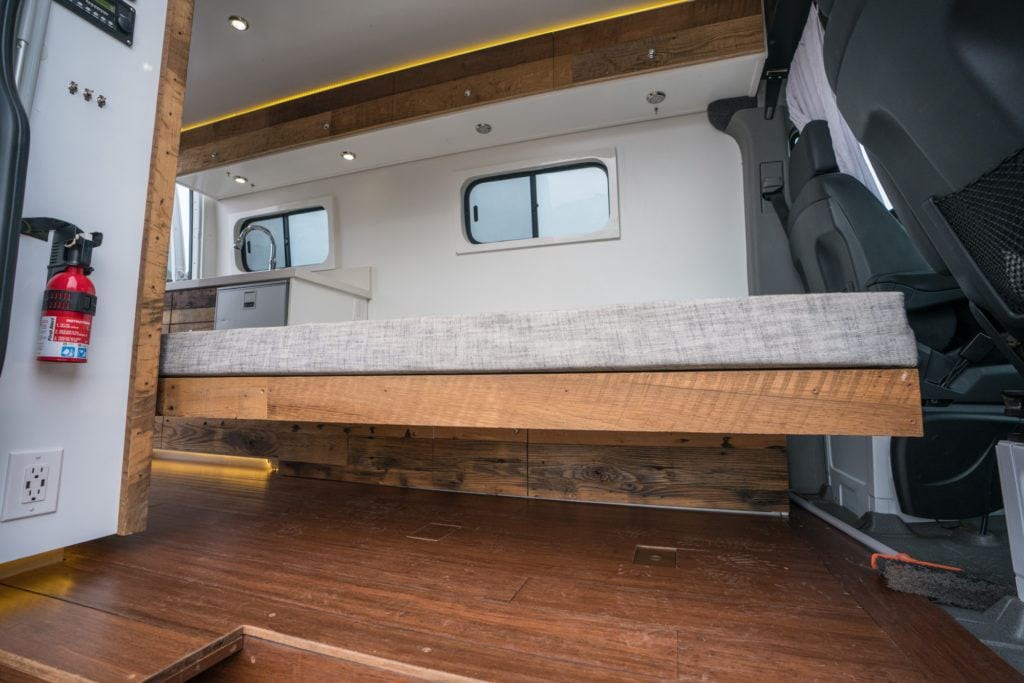 interior of a camper van from the side door with brown laminate van flooring