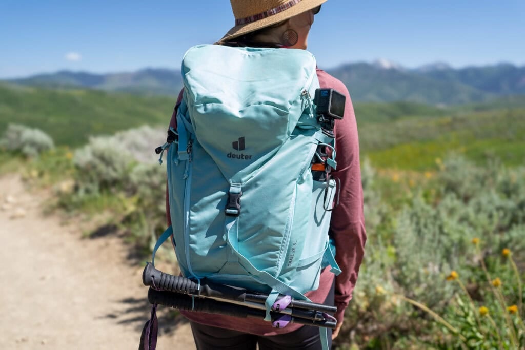 Kristen Bor wearing the Deuter Trail 28 SL backpack on a trail in Park City with green foliage