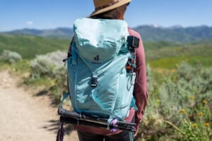 Kristen Bor wearing the Deuter Trail 28 SL backpack on a trail in Park City with green foliage