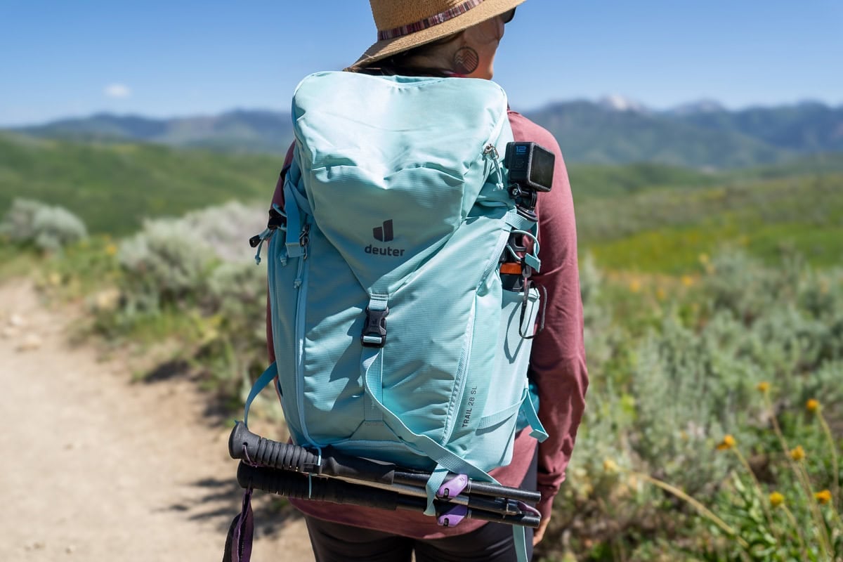 Kristen Bor wearing the Deuter Trail 28 SL backpack on a trail in Park City with green foliage