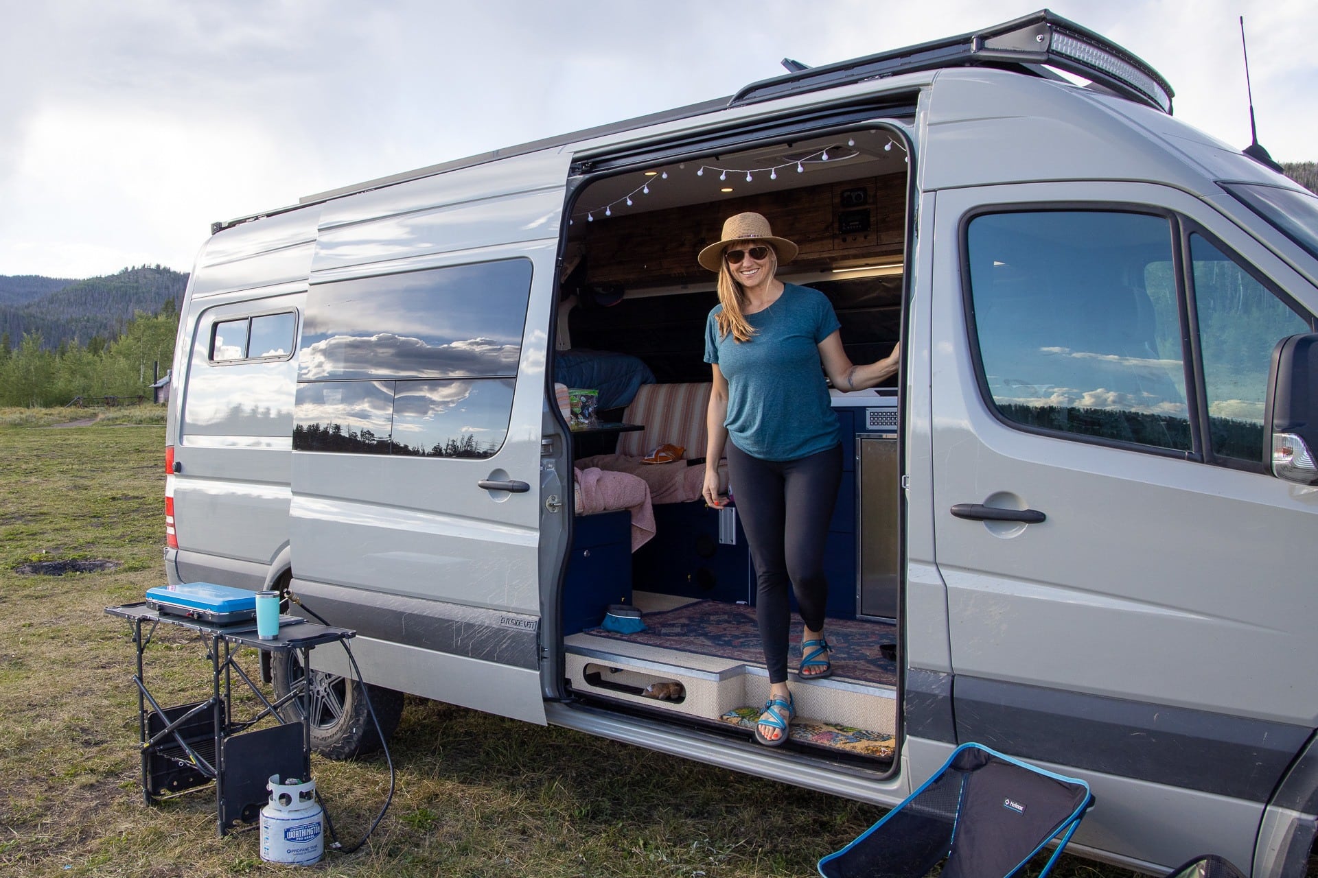 Bearfoot Theory founder Kristen Bor standing in doorway of her Sprinter Van at a dispersed campsite 