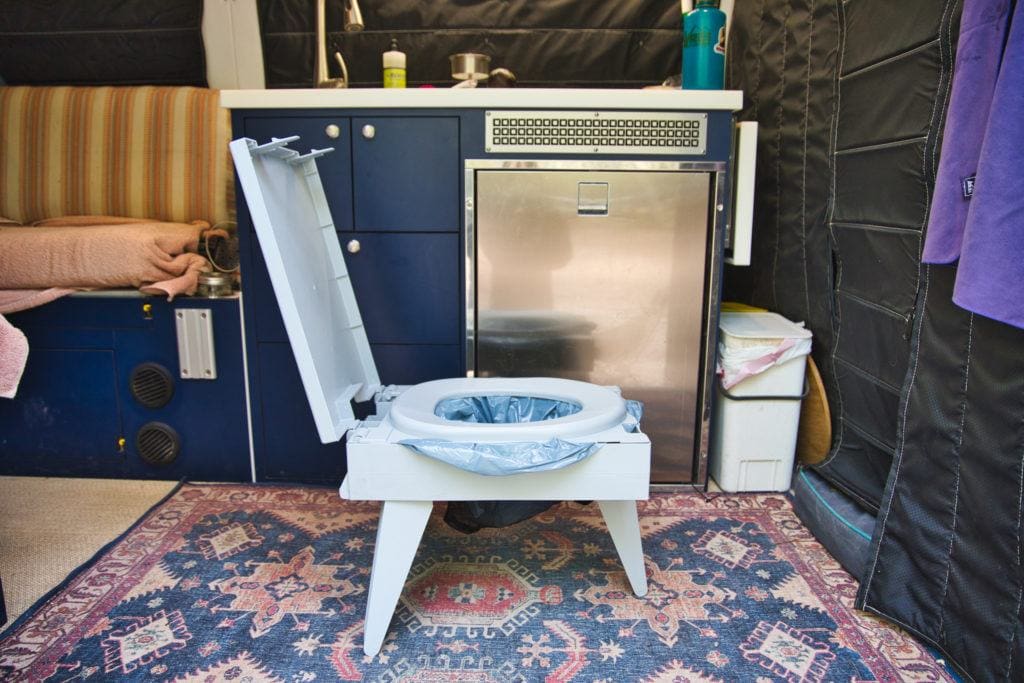 Portable toilet set up in living area of converted campervan