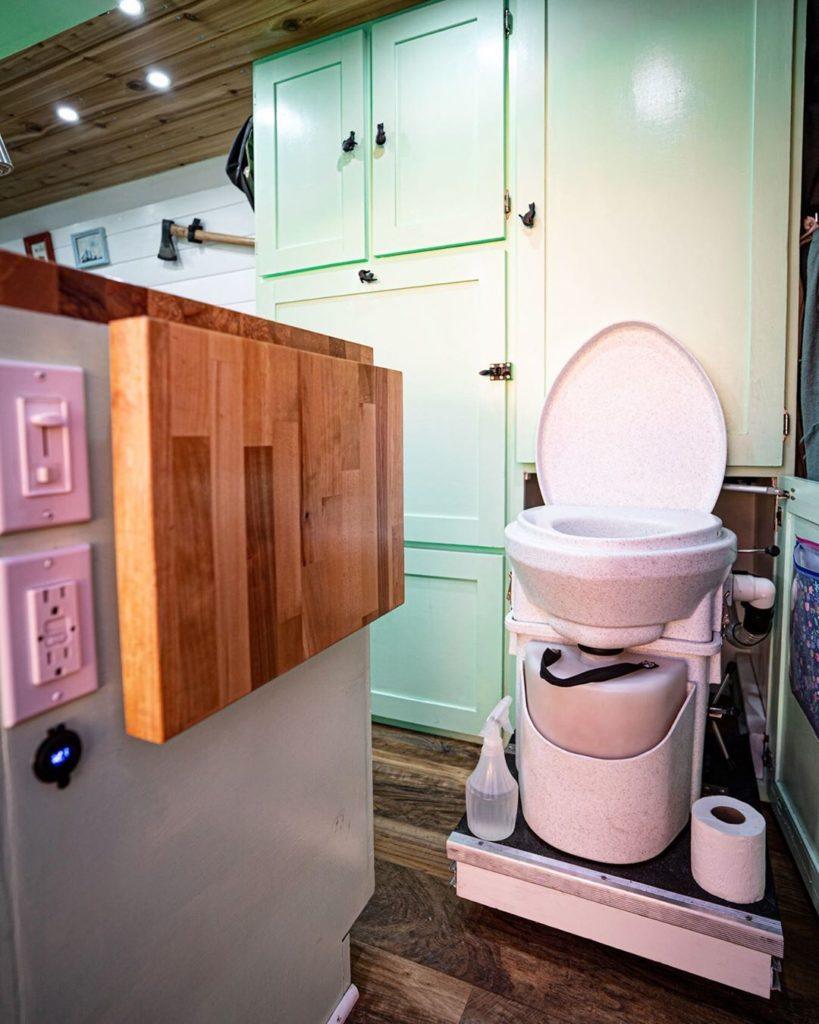 Hidden composting camper van toilet by @lindseyanddannyvanlife