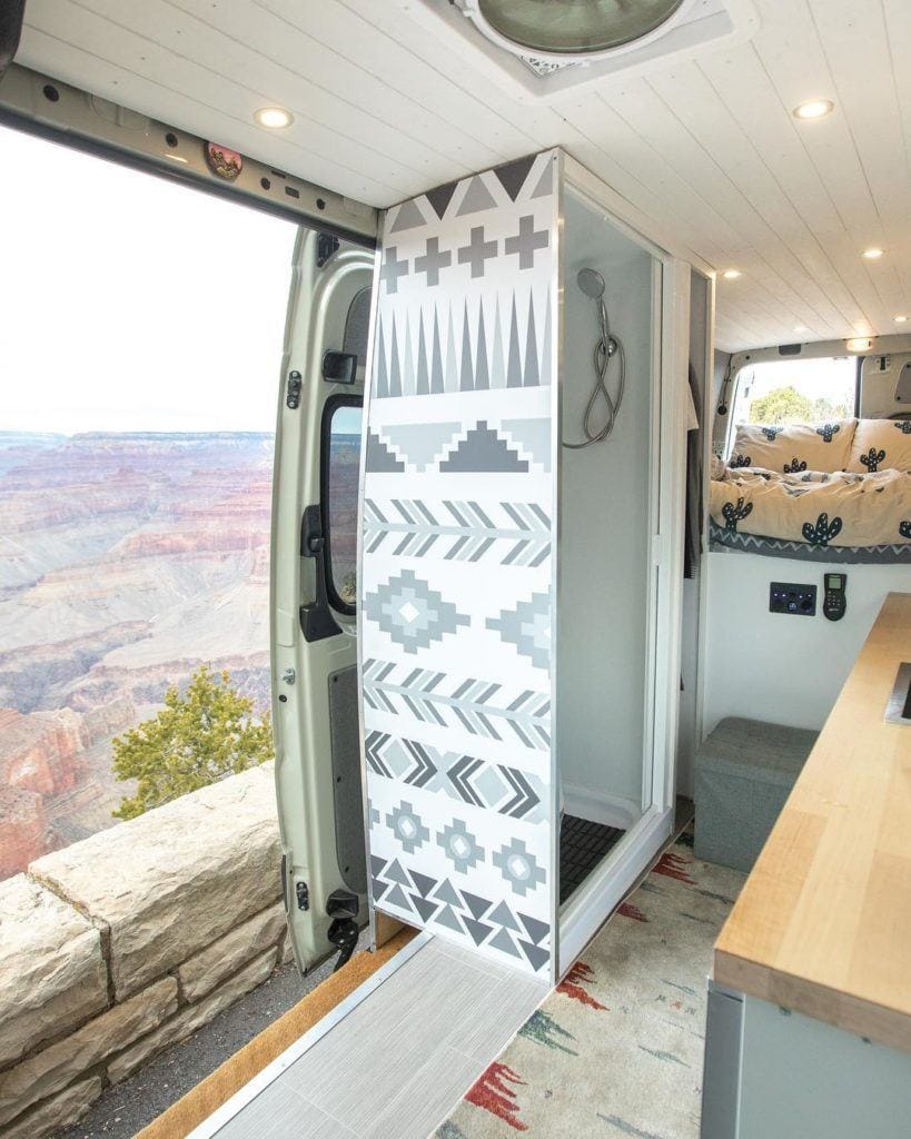 Camper van bathroom setup with indoor shower and portable toilet by @van_yacht