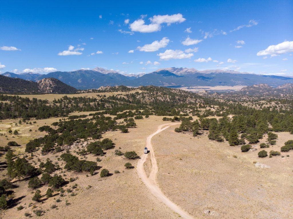 A drone shot of a Sprinter van driving down a dirt road near Buena Vista, Colorado