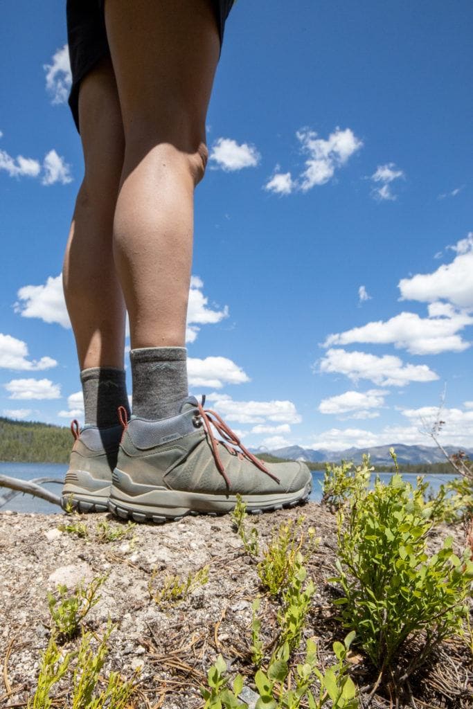 Closeup photo of a woman wearing the Oboz Sypes hiking boots on a hiking trail