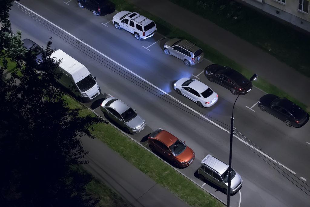 Birds eye view of road from building with cars parked on the sides