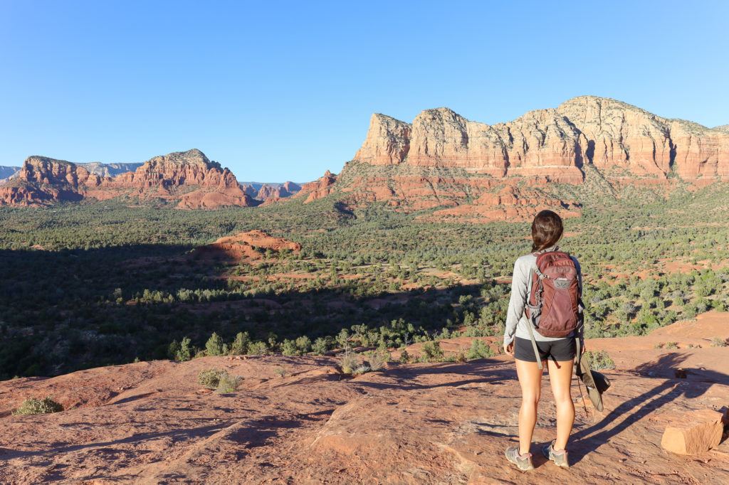 Woman standing at lookout wearing a hiking backpack in Sedona, Arizona