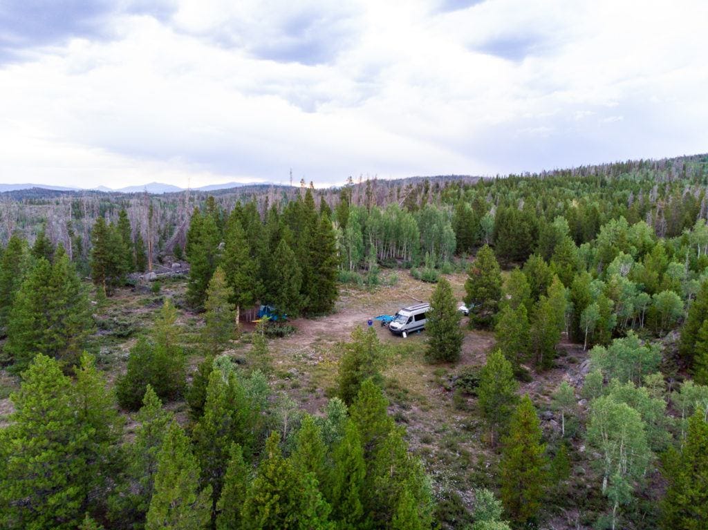 Camper van tucked into trees at remote dispersed campsite