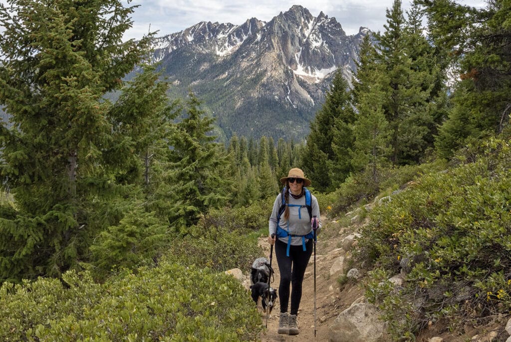 A woman hiking in Stanley, Idaho with two dogs wearing women's base layers