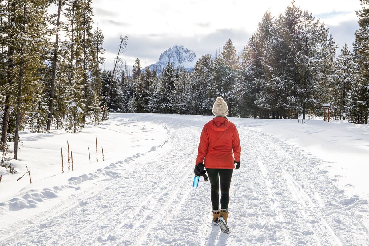 Woman hiking in winter snow - Explore the best winter hiking clothes, essential gear, and tips for layering for cold weather