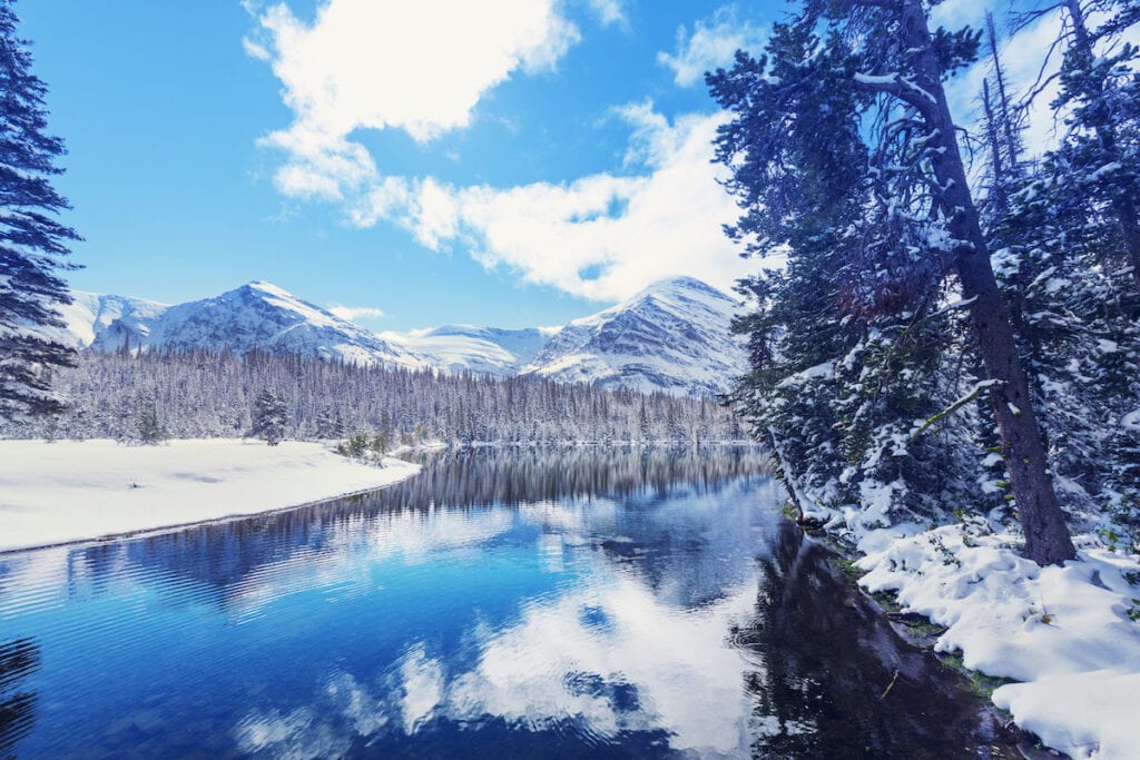 Views out over lake in winter with snowy landscape and mountains in background