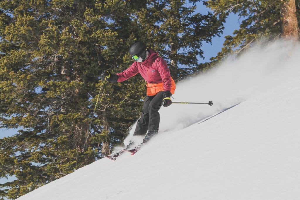 Woman skiing down steep slope on ski mountain