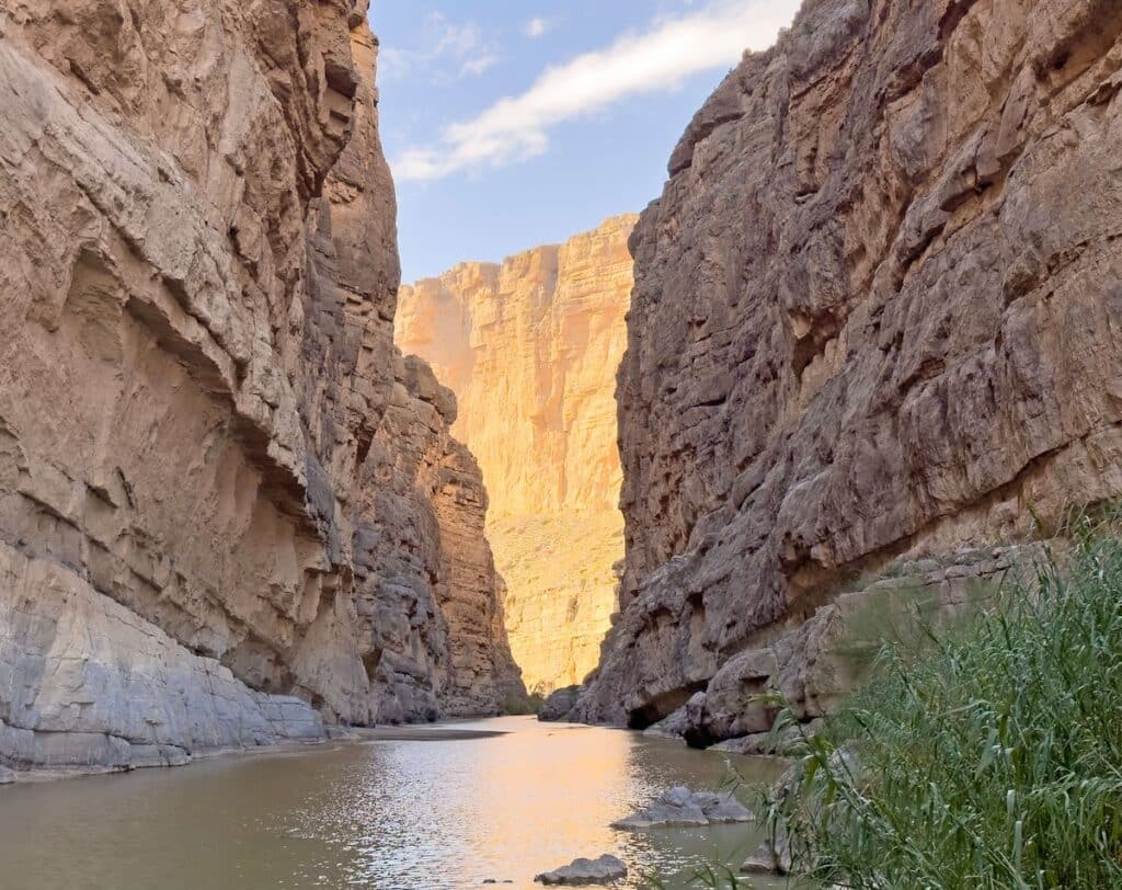 Tall canyon walls rising up from a shallow river in Boquillas Canyon in Big Bend National Park in Texas