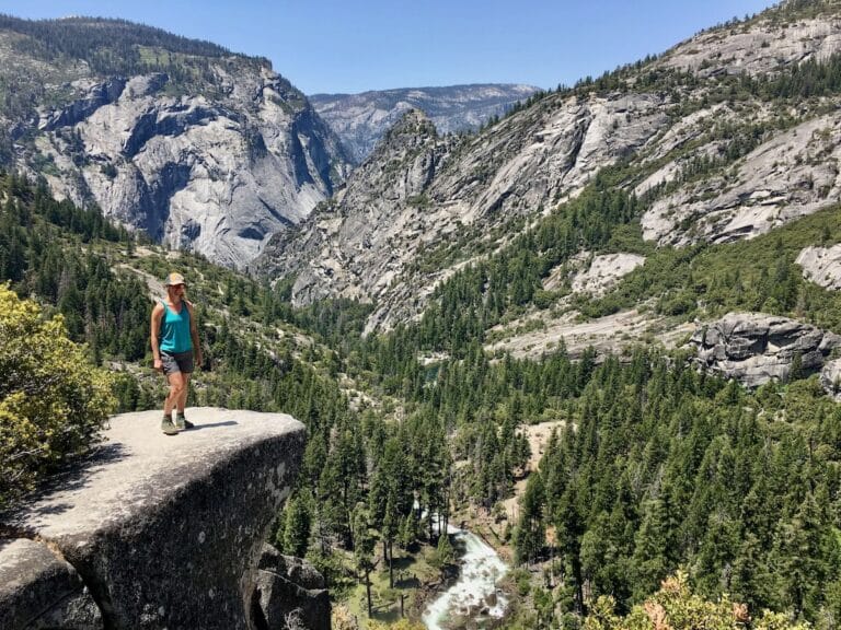 Woman standing at rock ledge lookout over Nevada Falls in Yosemite National Park