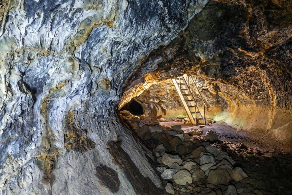 Stairs leading down to a lit lava tube in Lava Beds National Monument