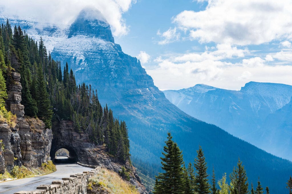 Tunnel through the mountain on Going to the Sun Road in Glacier National Park with dramatic mountain views in the background