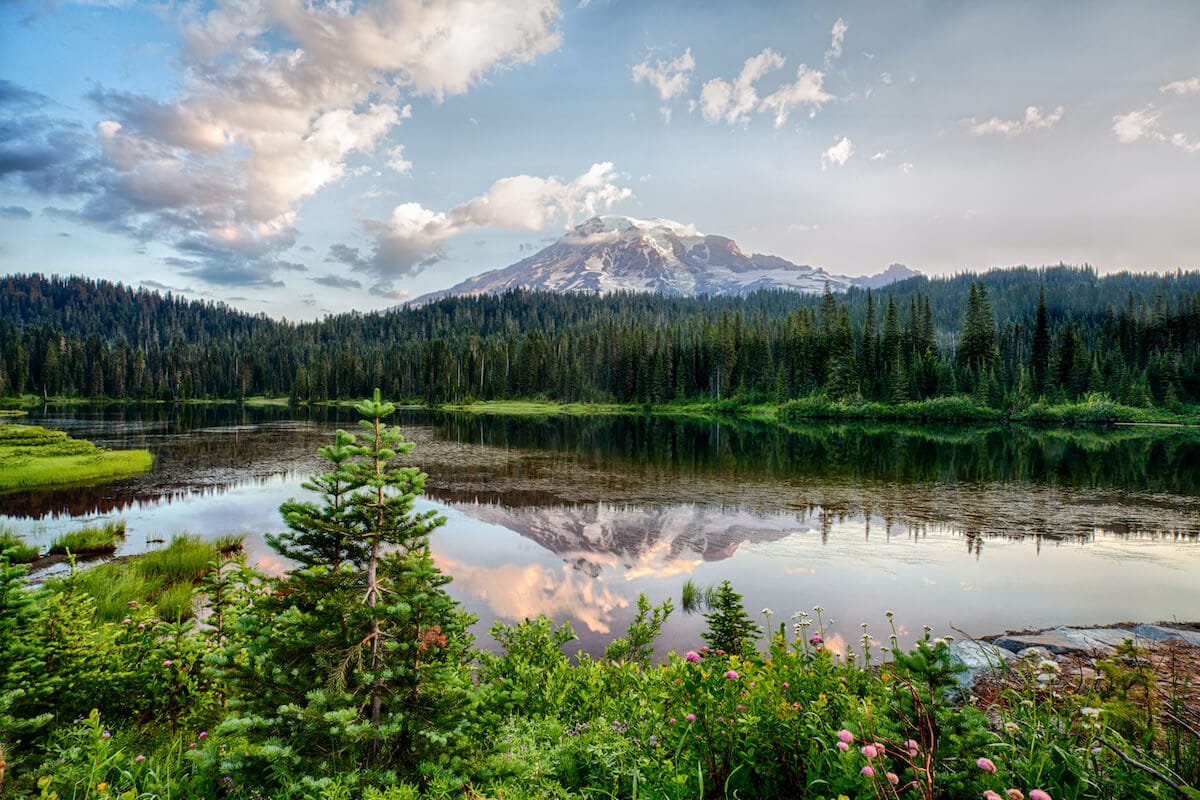 Landscape photo of snow-capped Mount Rainier with lake in foreground