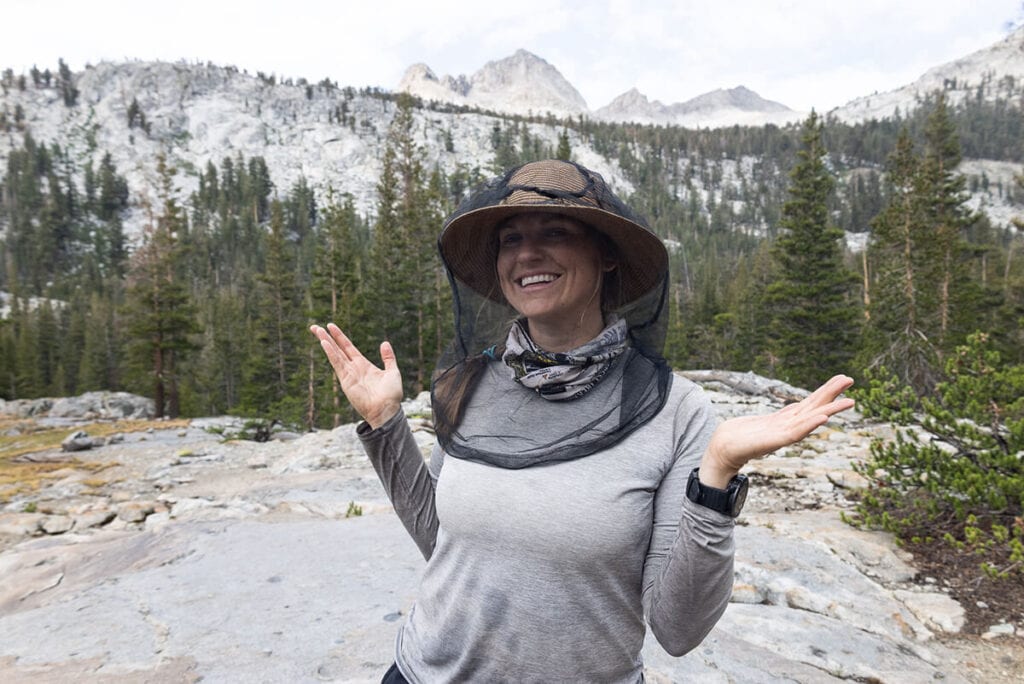 A woman wearing a bug head net while backpacking the Mineral King Loop in Sequoia National Park