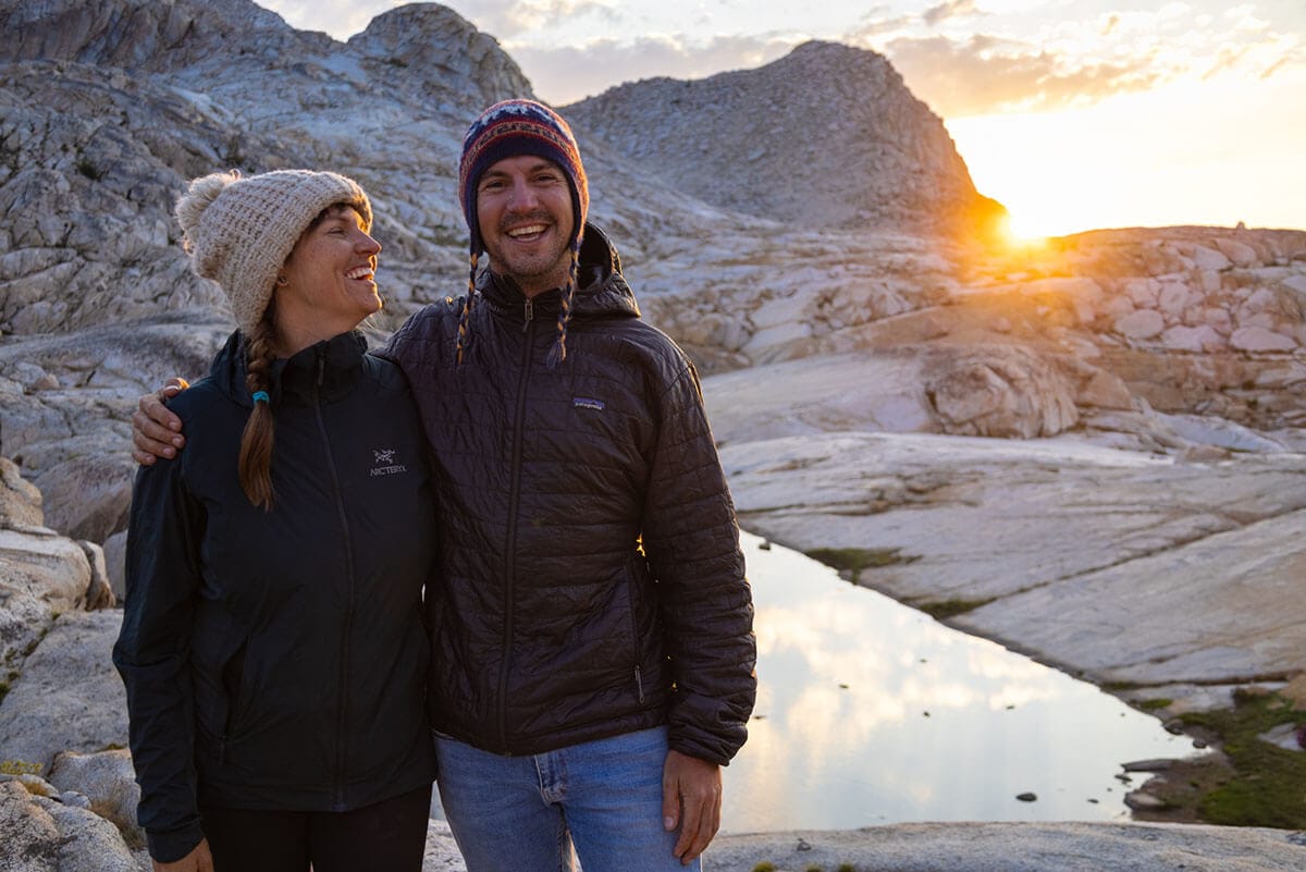 Two people with the sun setting behind them and the mountains in Sequoia National Park