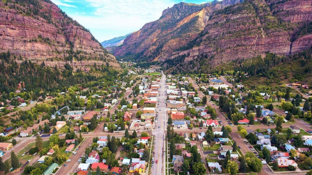 Birdseye view of Ouray Colorado with steep rock cliffs on both sides of the town