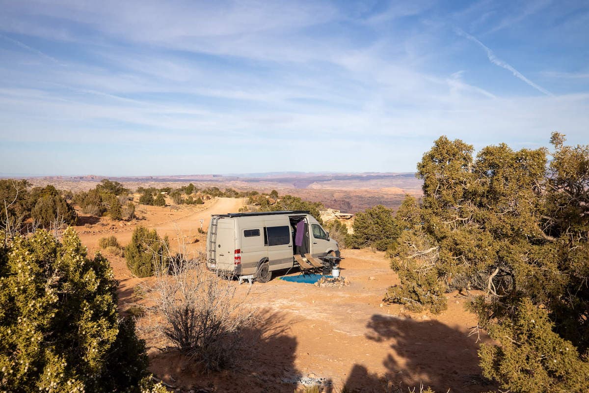 Sprinter Van parked at dispersed campsite in Moab overlooking red rock landscape