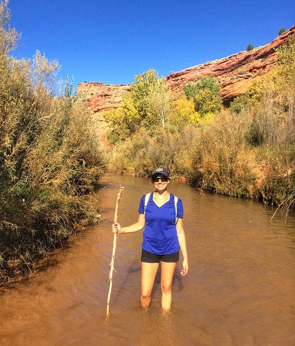 Bearfoot Theory founder Kristen Bor standing in the Escalante River on the hike to the Golden Cathedral in Grand Staircase-Escalante National Monument