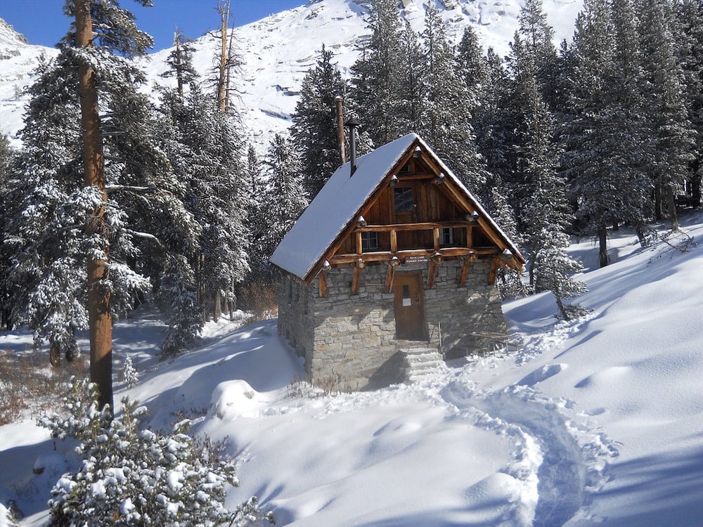 Pear Lake Backcountry Hut surrounded by winter forest landscape