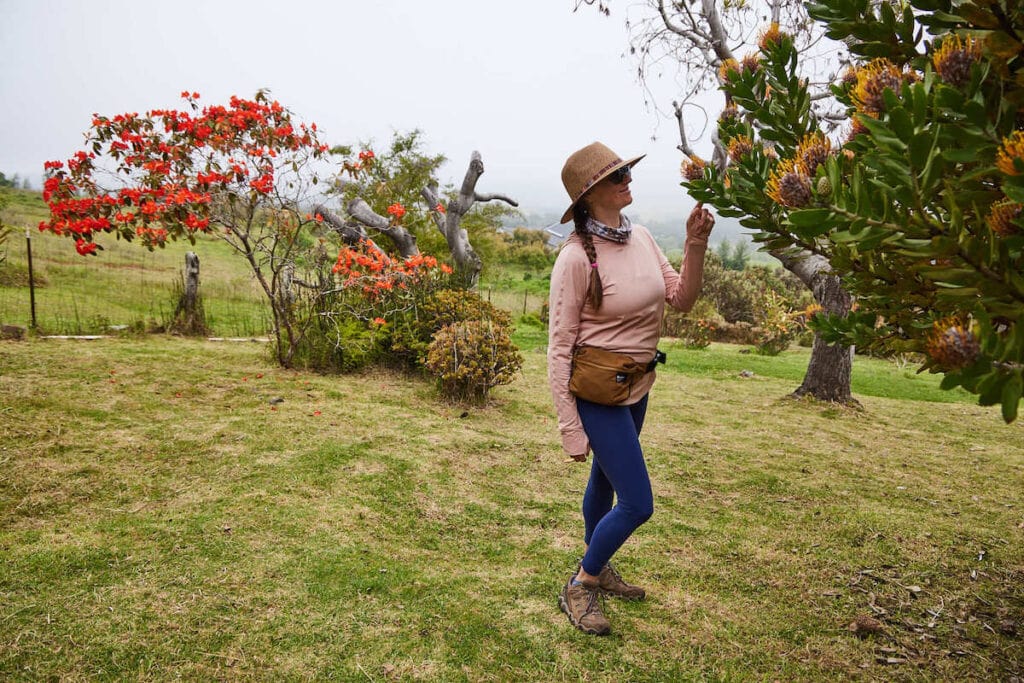 Kristen Bor smelling flowers in a tree on Maui