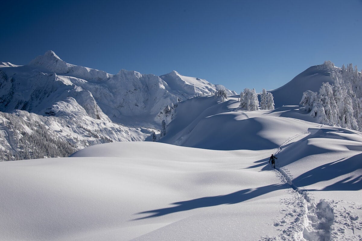 Person snowshoeing at Artist Point, Mount Baker // Explore the best Washington snowshoeing routes this winter with our detailed trail guides and important winter safety information.