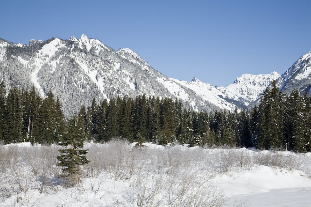 Snow covered mountains at Gold Creek Valley // Explore the best Washington snowshoeing routes this winter with our detailed trail guides and important winter safety information.