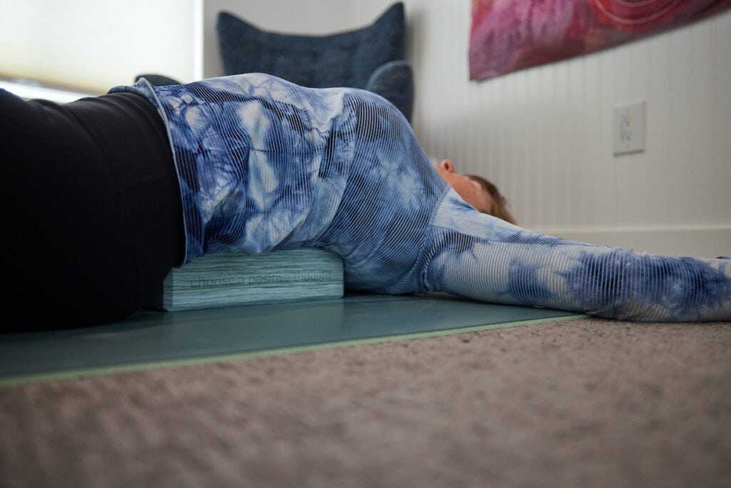 Woman using the lululemon Lift and Lengthen Yoga Block