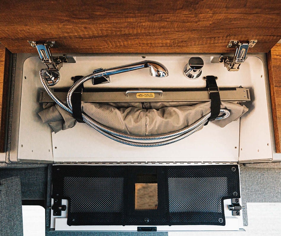 Hidden portable shower system designed for converted camper vans 