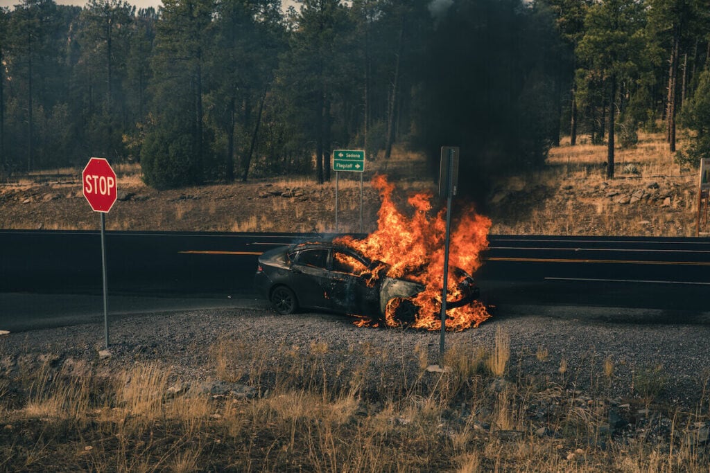 a car on fire off the side of the highway in Arizona between Flagstaff and Sedona