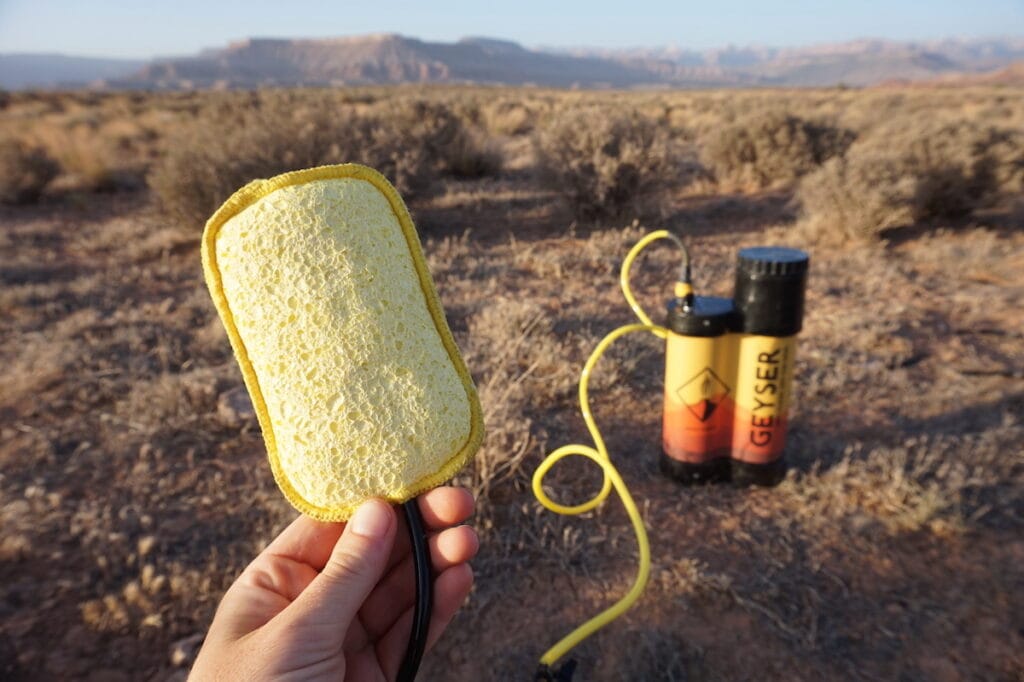 Holding the sponge attachment while reviewing the Geyser Systems Portable Shower With Heater