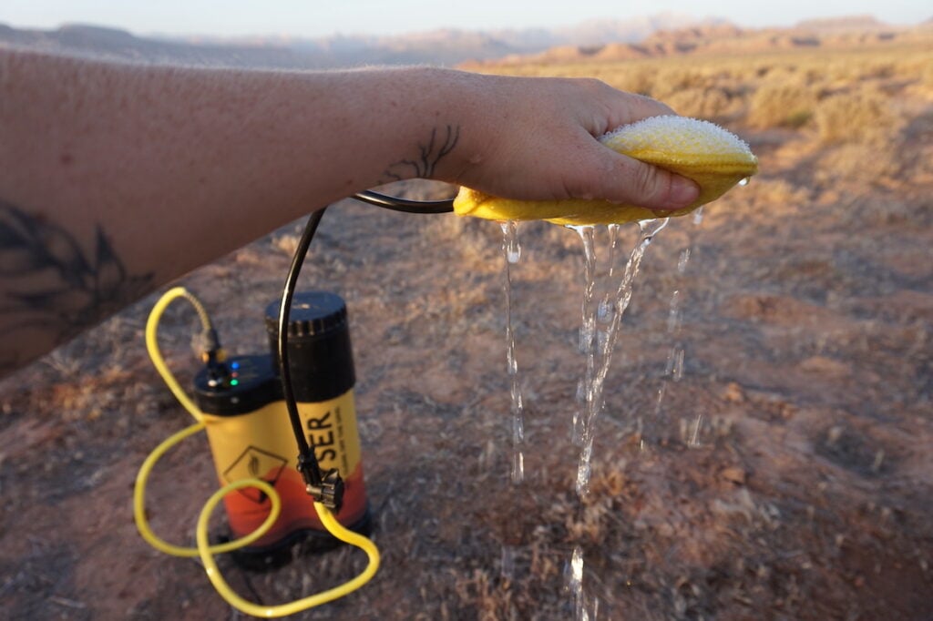 The sponge attachment with water spraying down from Geyser Systems Portable Shower With Heater