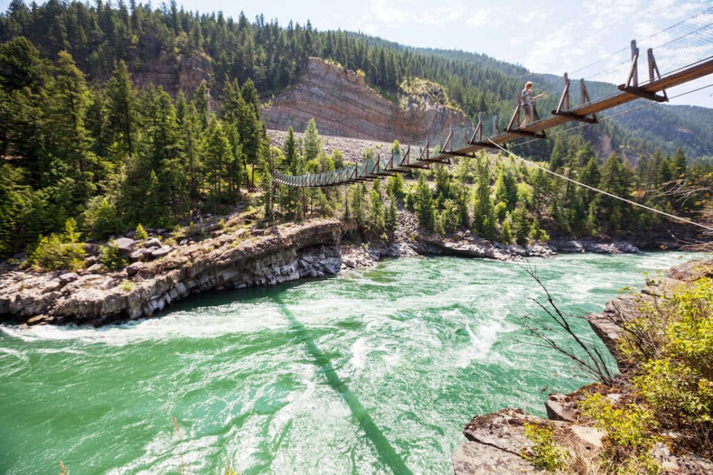 Narrow footbridge spanning river in Montana