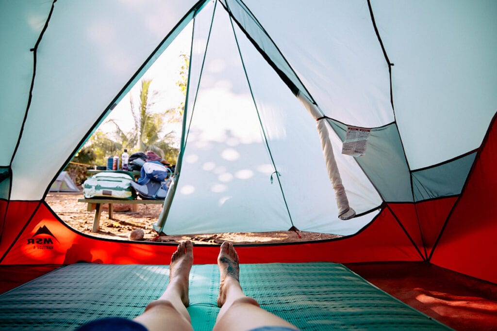 View from inside of a tent looking out to a campsite from laying on a sleeping pad