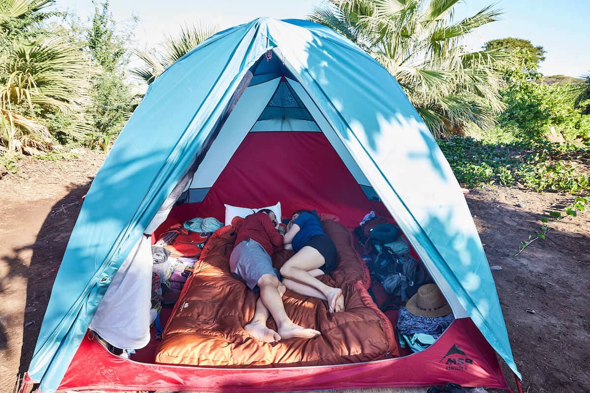 Two people in tent lying on top of double sleeping bag