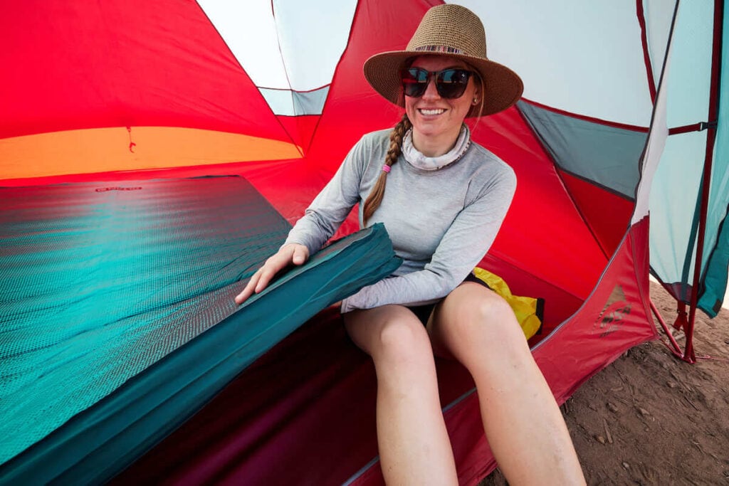 Bearfoot Theory founder Kristen Bor in a tent holding the NEMO Double Roamer Sleeping pad and showing it's thickness