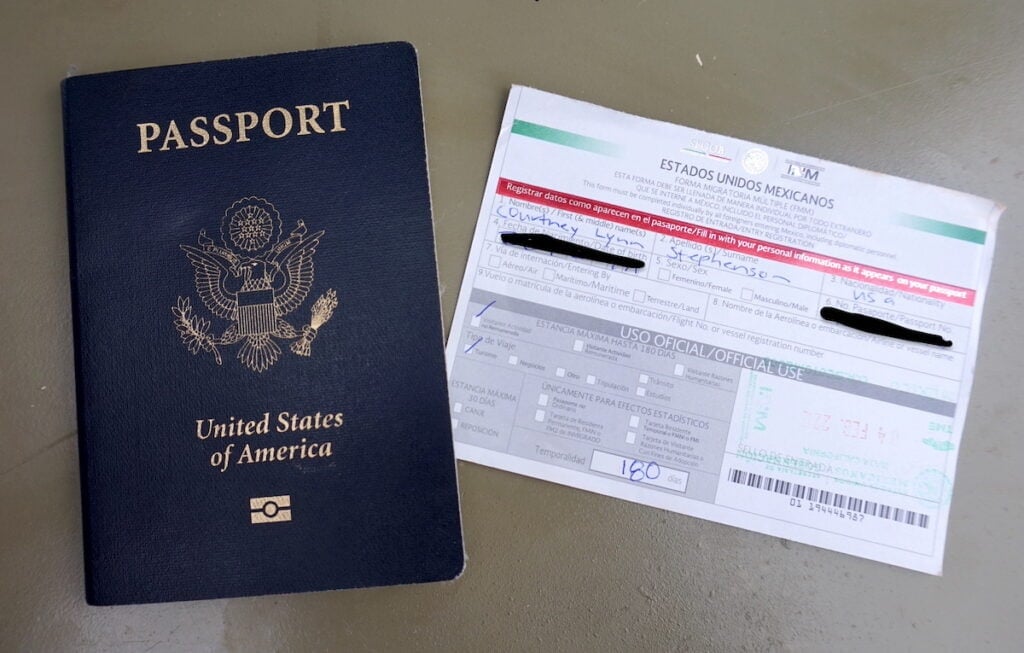 A US passport with a Mexican FMM Card temporary tourist visa next to it