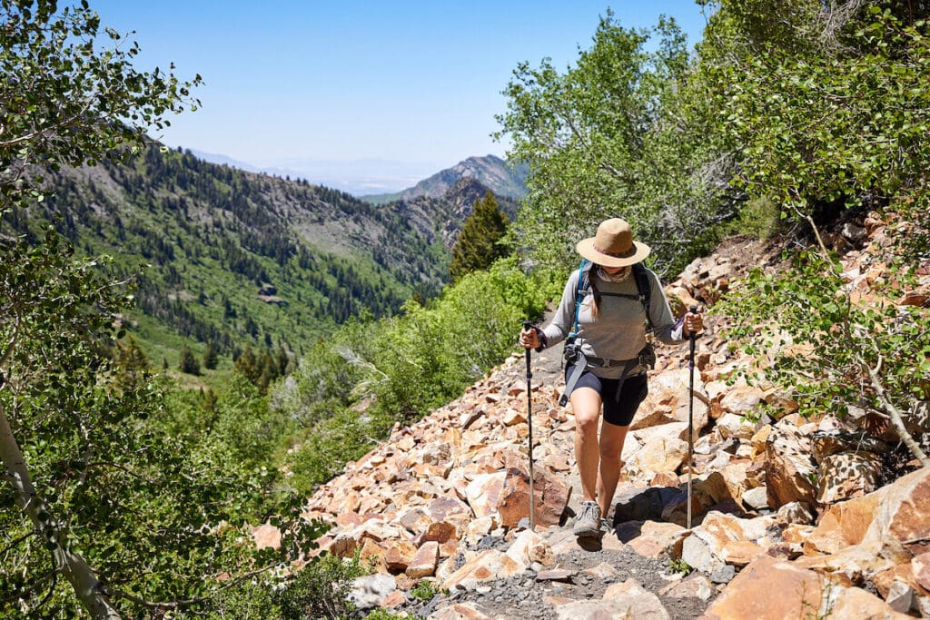 A woman hikes up a rocky mountain wearing Oboz Sawtooth X hiking boots