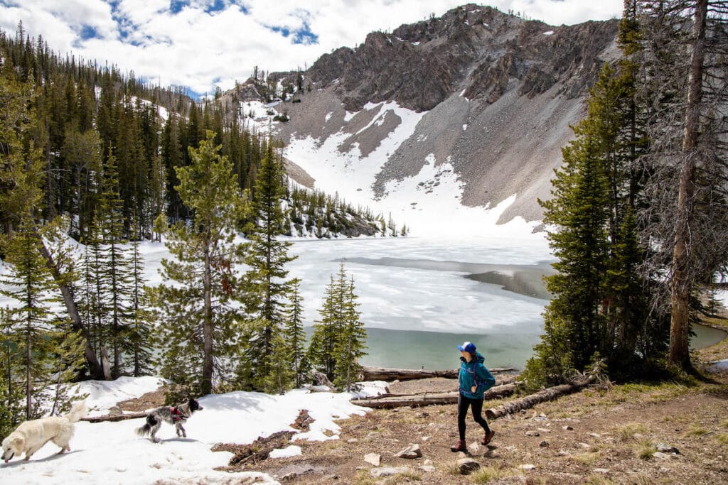 Hiker on trail next to ice and snow-covered lake in Sun Valley, Idaho