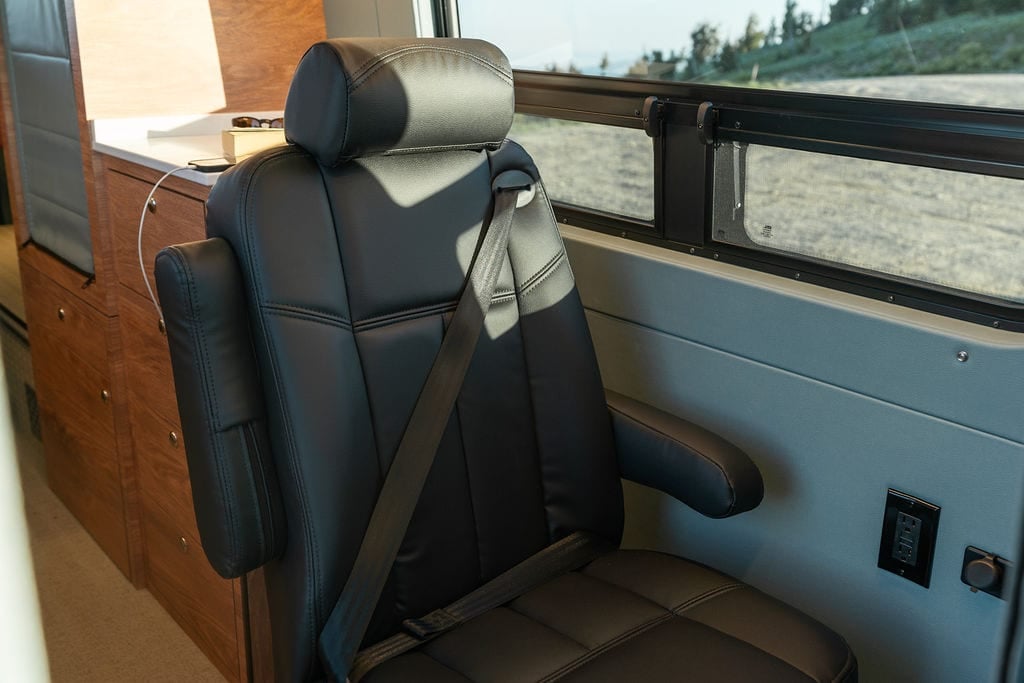 DOT Approved seat with seatbelt provides a third passenger seat in a Sprinter camper van.